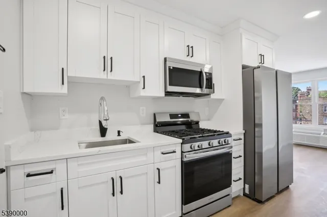 a kitchen with white cabinets and stainless steel appliances