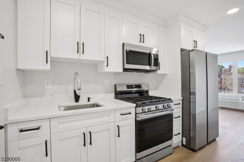 a kitchen with white cabinets and stainless steel appliances