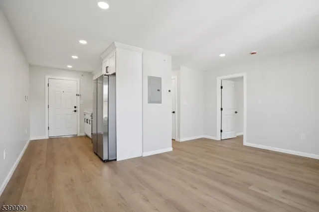 a view of an empty room with wooden floor