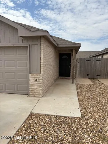 a view of an empty room with wooden floor and a ceiling fan