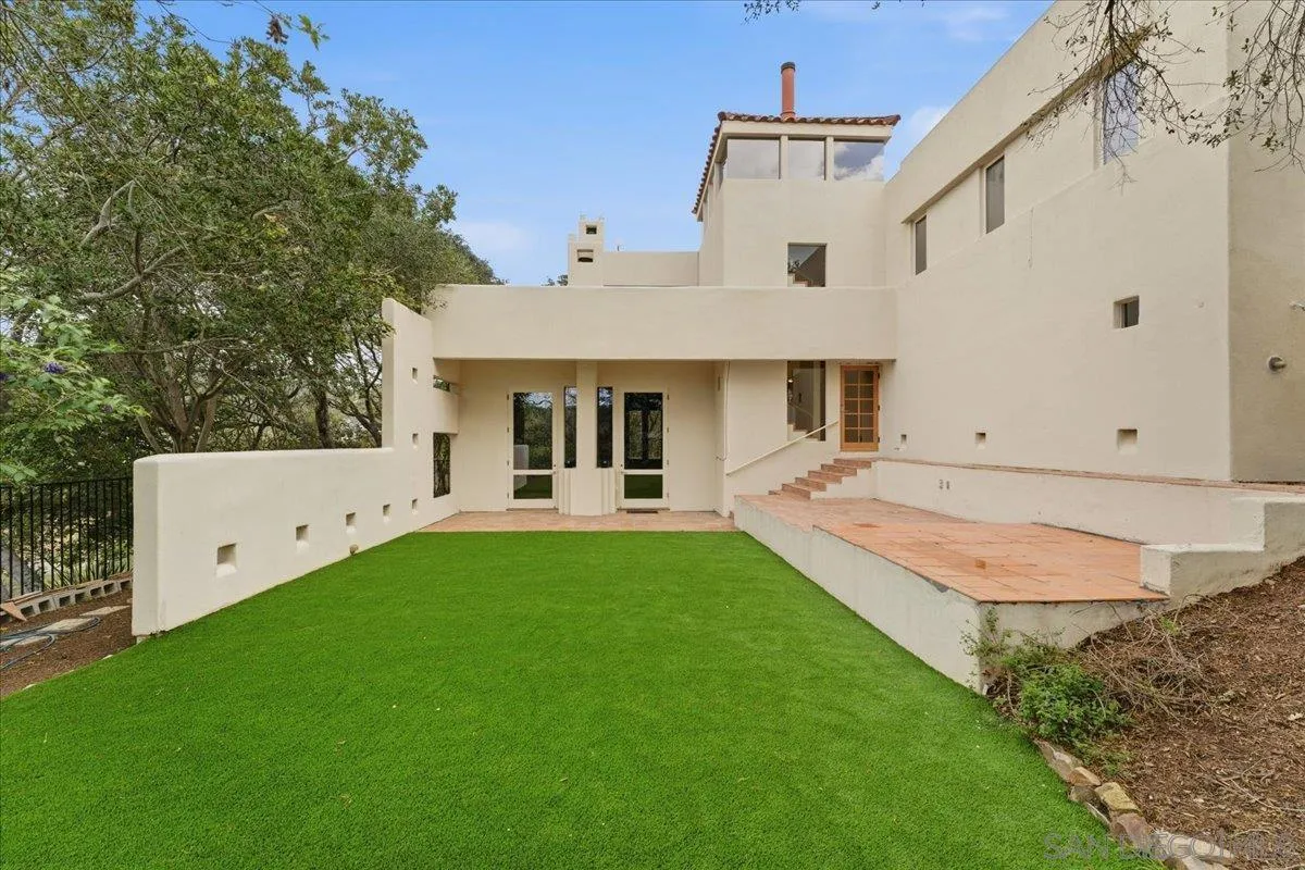 7030 Elfin Oaks Road Escondido, CA 92029 - Photo 24 of 36 a front view of a house with a garden and yard