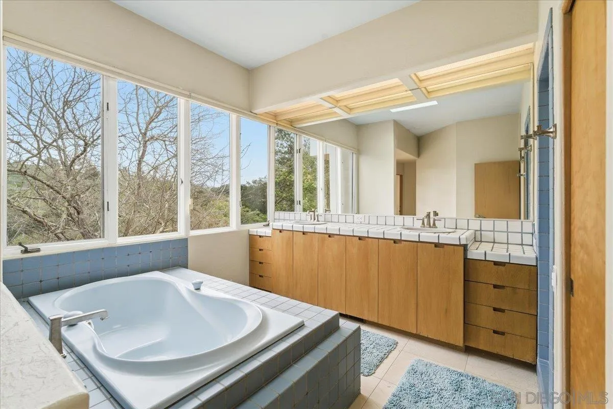 7030 Elfin Oaks Road Escondido, CA 92029 - Photo 34 of 36 a bathroom with a sink and a large mirror