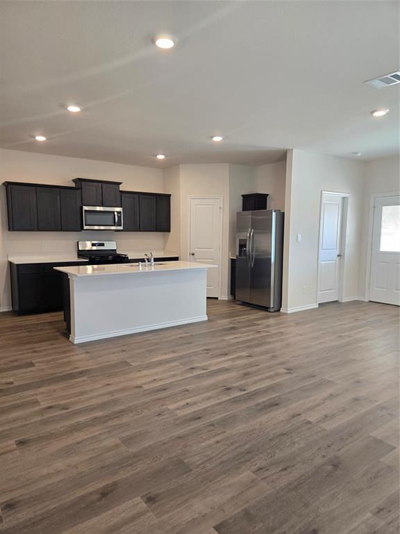 729 Lantana Lane Pilot Point, TX 76258 - Photo 3 of 19 a kitchen with stainless steel appliances kitchen island granite countertop a refrigerator and a stove top oven