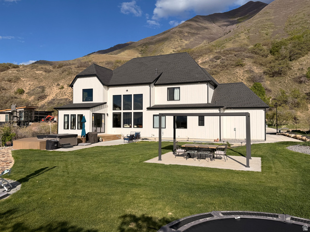 3626 Riverstone Road Mapleton, UT 84664 - Photo 50 of 58 Back of house with an outdoor fire pit, a hot tub, a mountain view, roof with shingles, and a patio