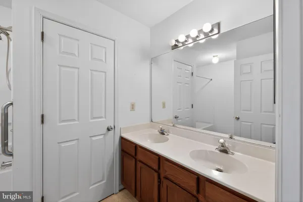 a bathroom with a double vanity sink and a mirror
