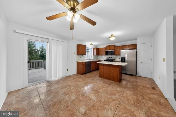 a kitchen with stainless steel appliances kitchen island granite countertop a refrigerator and a stove top oven