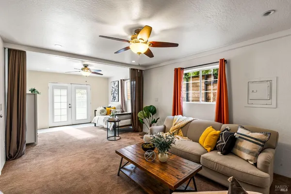 a living room with furniture a chandelier and a window