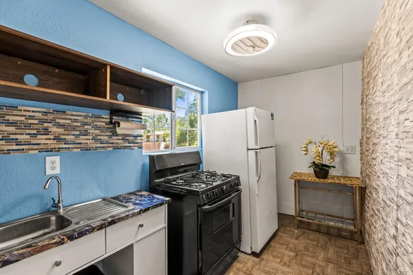 a kitchen with stainless steel appliances granite countertop a refrigerator and a stove