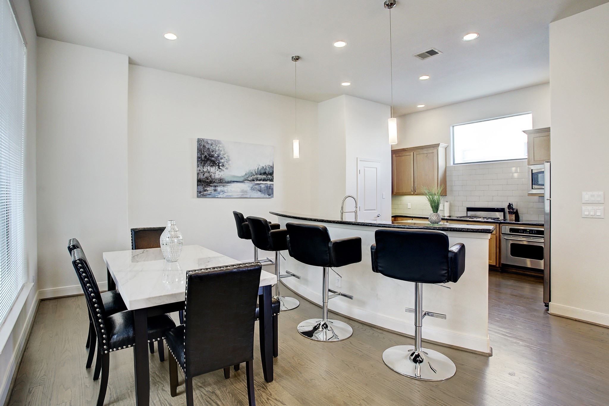 902 Roy Street Houston, TX 77007 - Photo 7 of 47 a kitchen with a dining table chairs and white cabinets