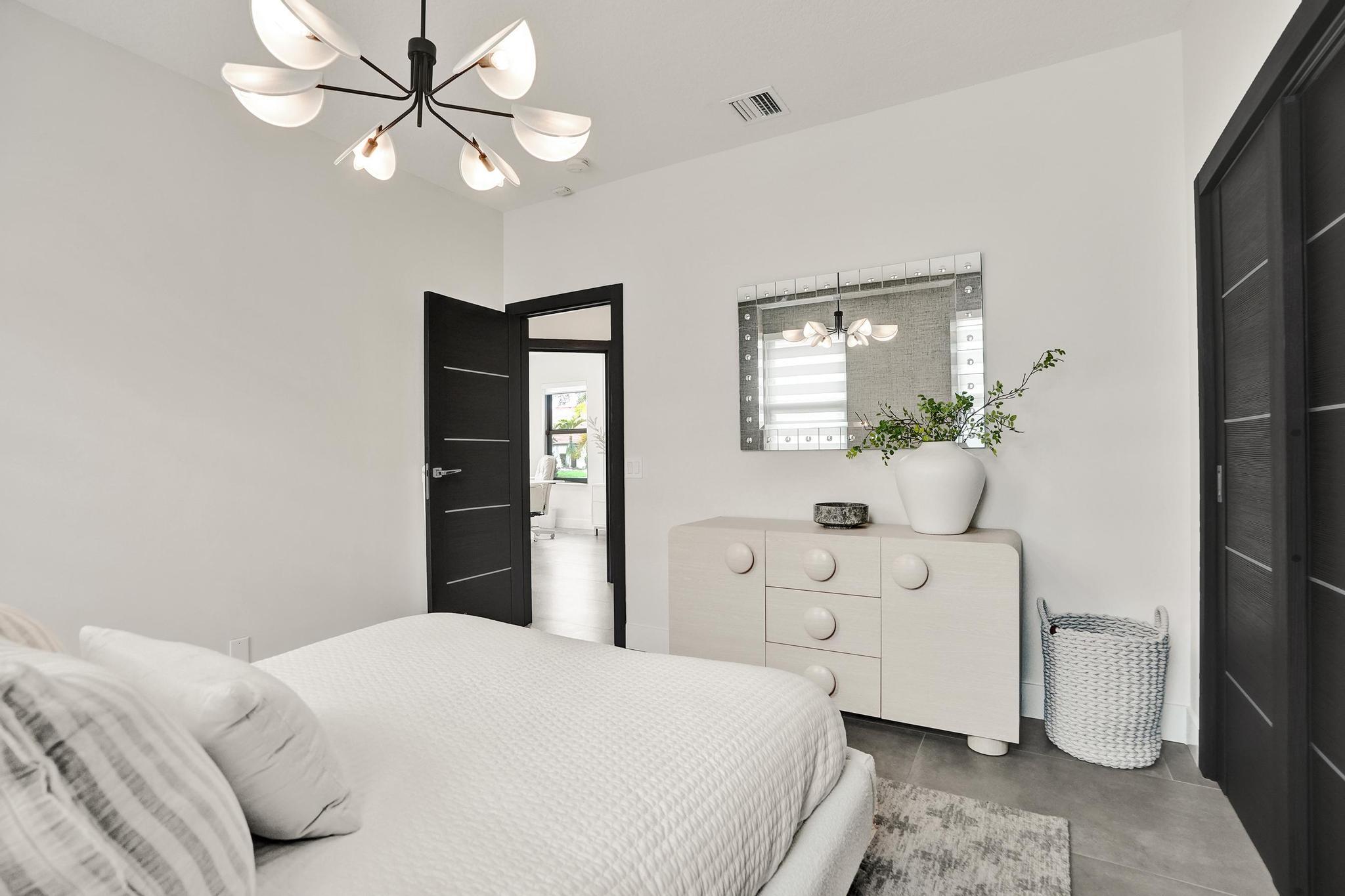 3222 Ridge Trace Davie, FL 33328 - Photo 49 of 77 a bedroom with a bed and a chandelier