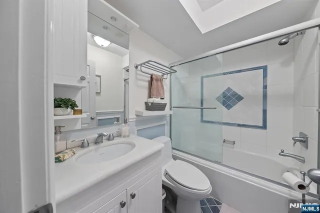 a bathroom with a sink a toilet a glass door and shower