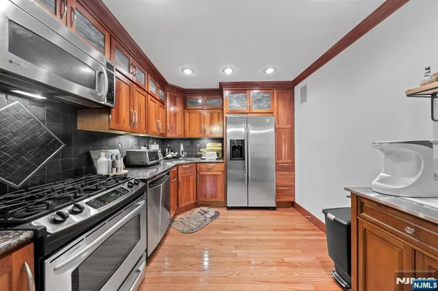 a kitchen with stainless steel appliances granite countertop a stove and a refrigerator