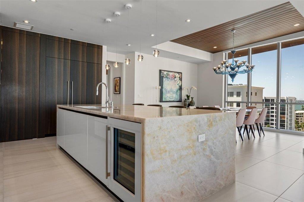 111 Golden Gate Point, Unit 802PH Sarasota, FL 34236 - Photo 10 of 55 a kitchen with kitchen island a counter top space a sink stainless steel appliances and cabinets