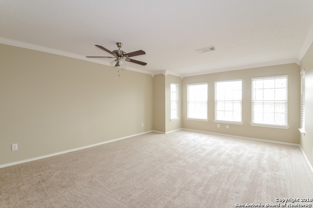 8423 Manderly Place Converse, TX 78109 - Photo 6 of 10 an empty room with a ceiling fan and windows