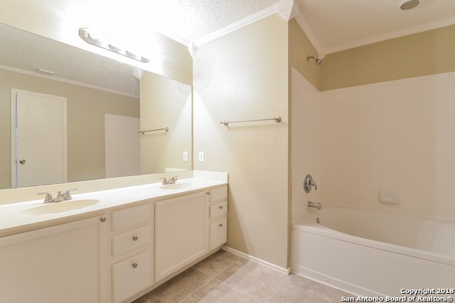 8423 Manderly Place Converse, TX 78109 - Photo 7 of 10 a bathroom with a double vanity sink a mirror and a bathtub