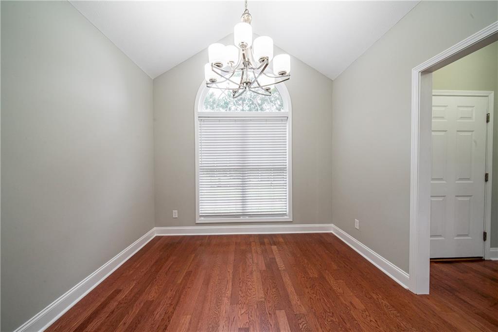 1927 Lee Road Salem, AL 36874 - Photo 26 of 45 Spare room featuring a chandelier, dark wood-type flooring, and lofted ceiling