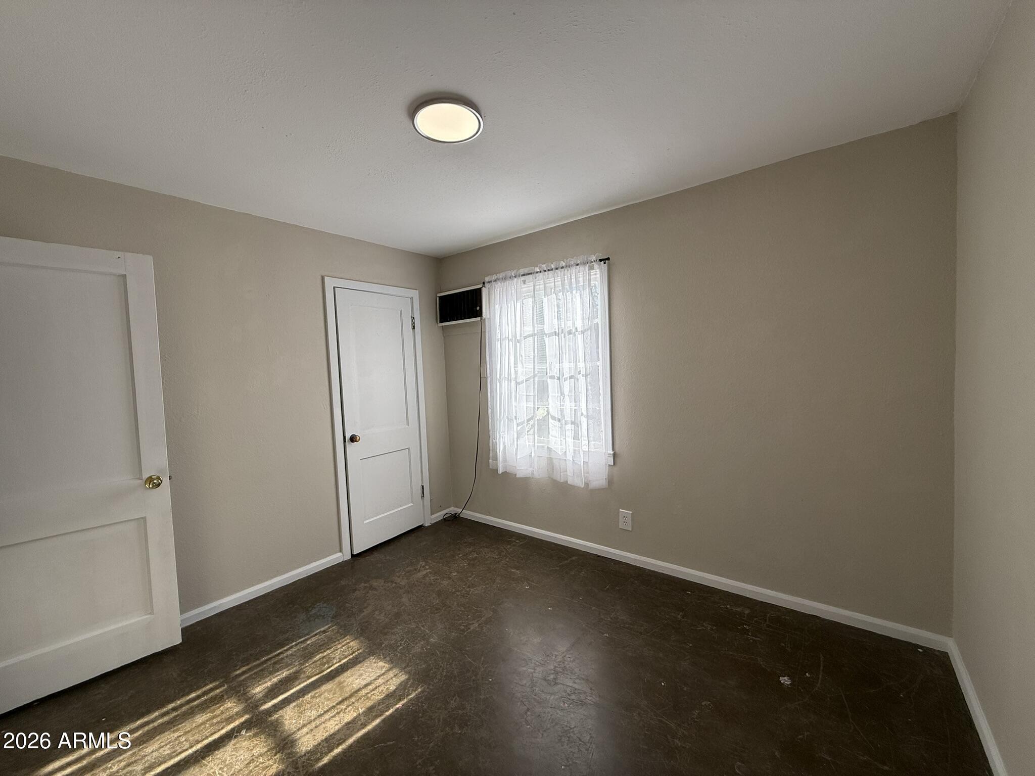 91 Neptune Avenue Bisbee, AZ 85603 - Photo 7 of 12 a view of an empty room with wooden floor and a window