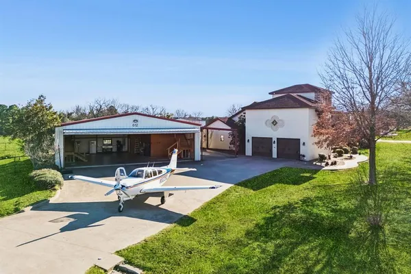 a front view of a house with garden and sitting area