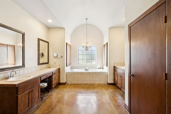 a bathroom with a tub sink shower and mirror