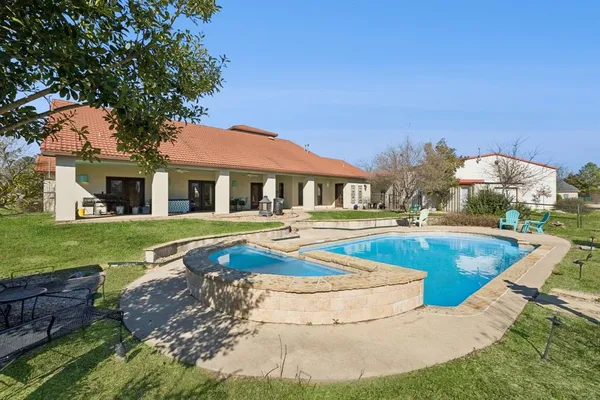 a view of a house with swimming pool and a yard