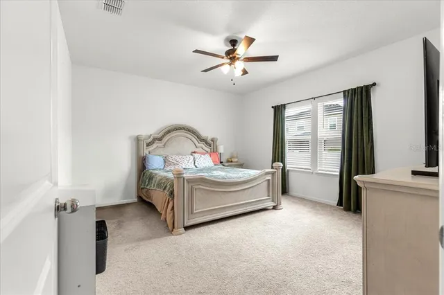 a bedroom with a bed and a ceiling fan