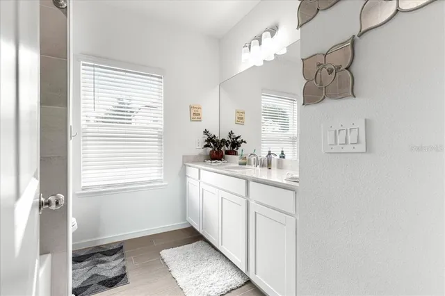 a bathroom with a sink a mirror and a window