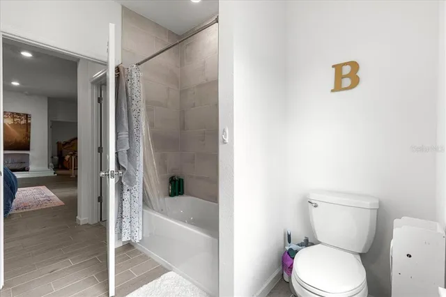 a white toilet sitting next to a bath tub