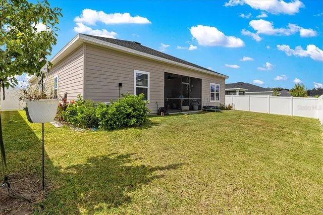 a view of a house with a yard and potted plants