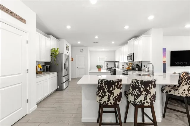 a large kitchen with a table and chairs