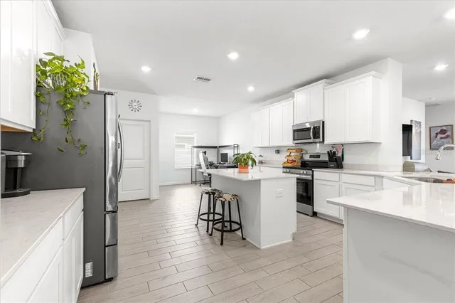 a kitchen with white cabinets and stainless steel appliances