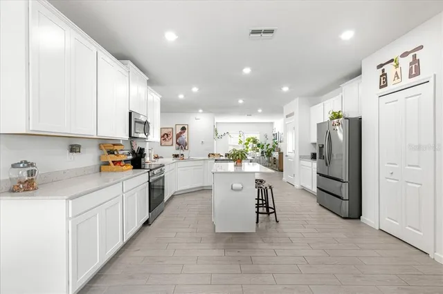 a kitchen with white cabinets and stainless steel appliances
