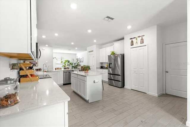 a kitchen with stainless steel appliances granite countertop a refrigerator and a sink