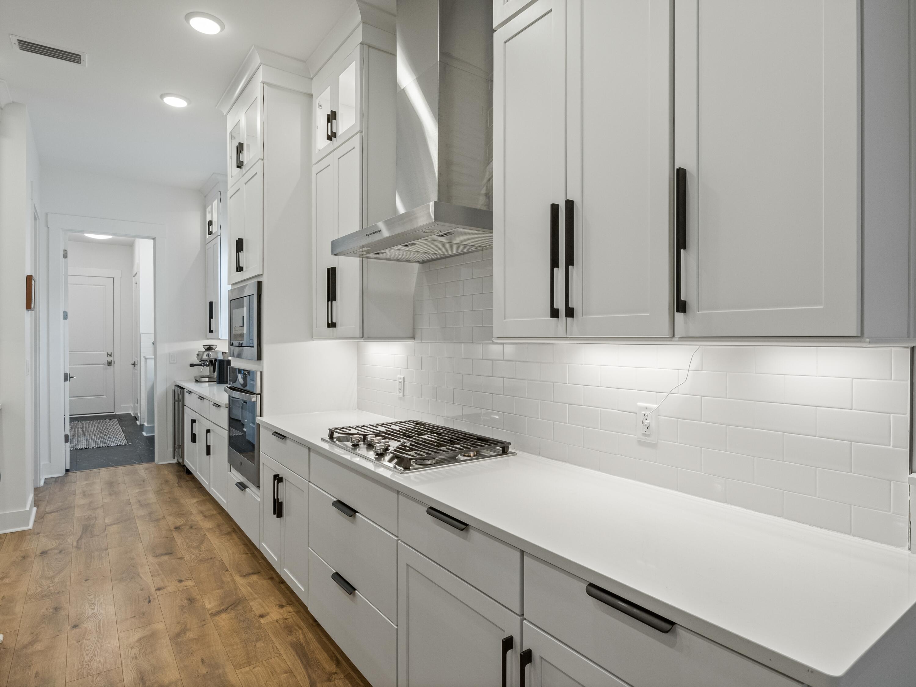 298 Lafayette Road Watersound, FL 32461 - Photo 20 of 76 a kitchen with granite countertop a sink stove and cabinets
