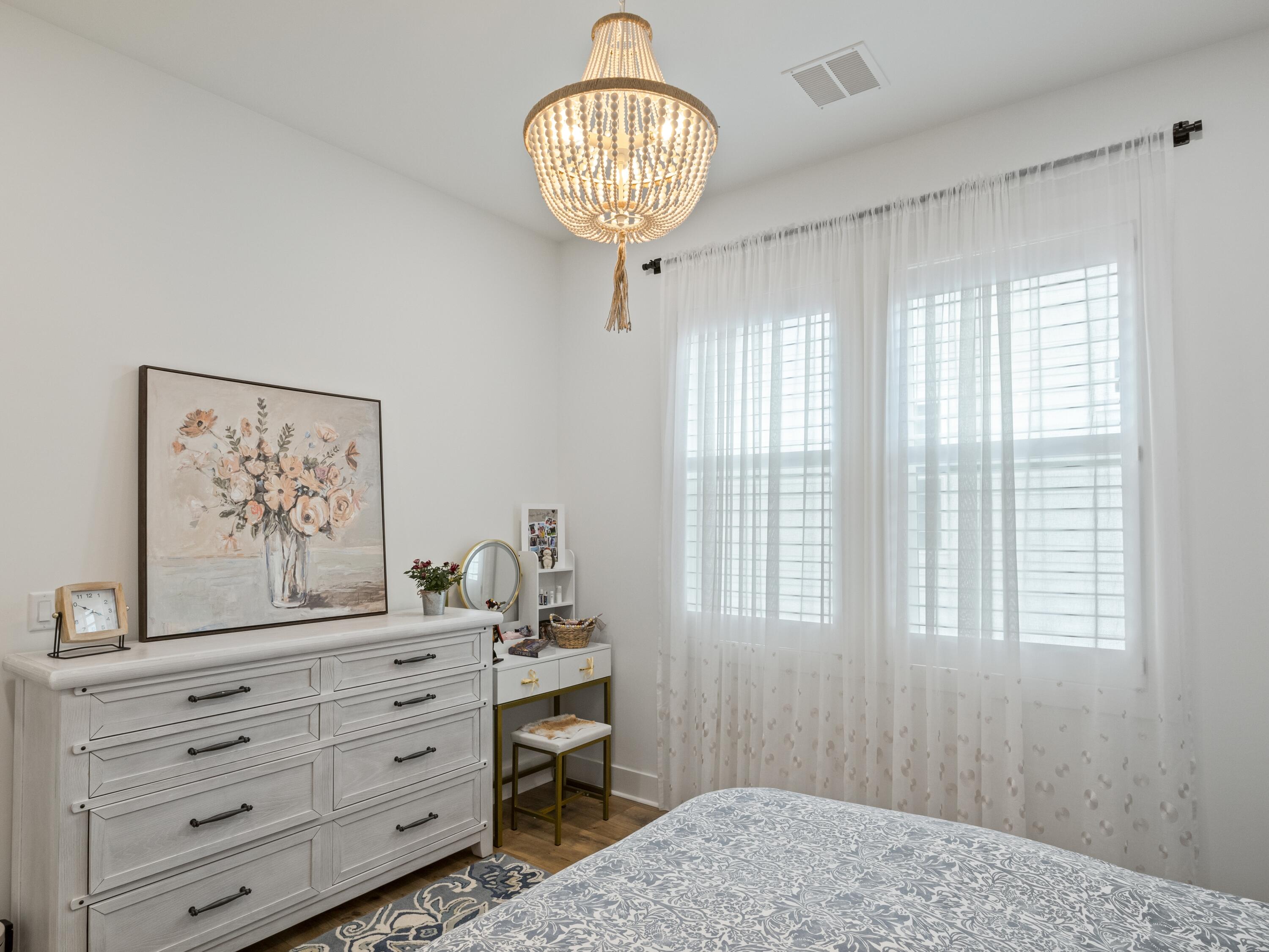 298 Lafayette Road Watersound, FL 32461 - Photo 46 of 76 a bedroom with a bed and a chandelier