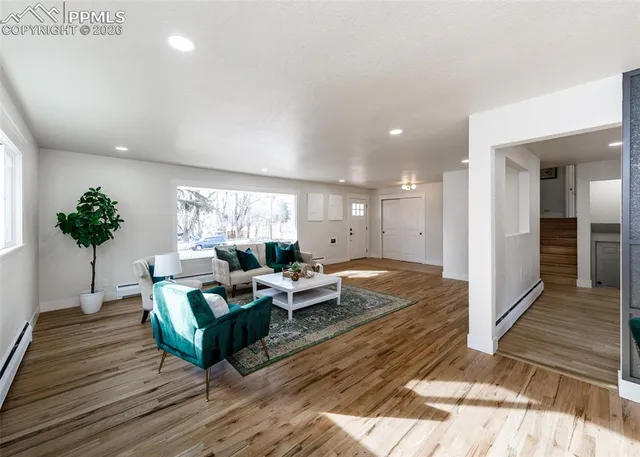 a living room with furniture and a wooden floor