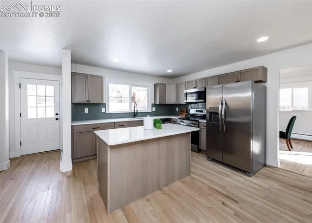 a kitchen with stainless steel appliances a refrigerator a sink a stove a microwave and cabinets