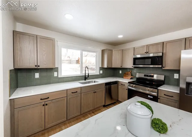 a kitchen with a sink a stove a microwave and cabinets