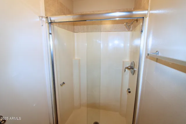 a bathroom with a glass shower door and a bathroom