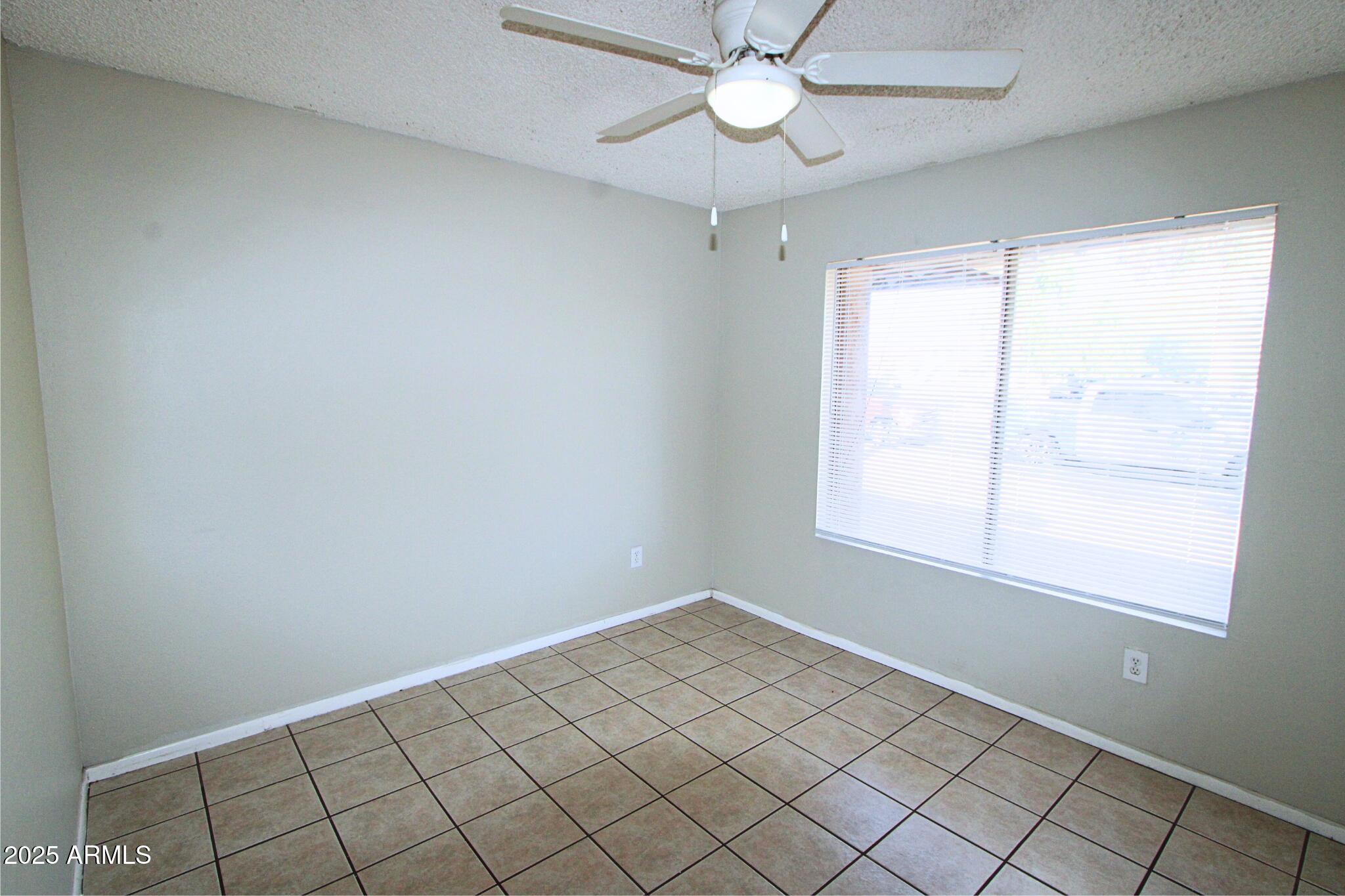 3313 West Harmont Drive, Unit 1 Phoenix, AZ 85051 - Photo 12 of 16 an empty room with a window