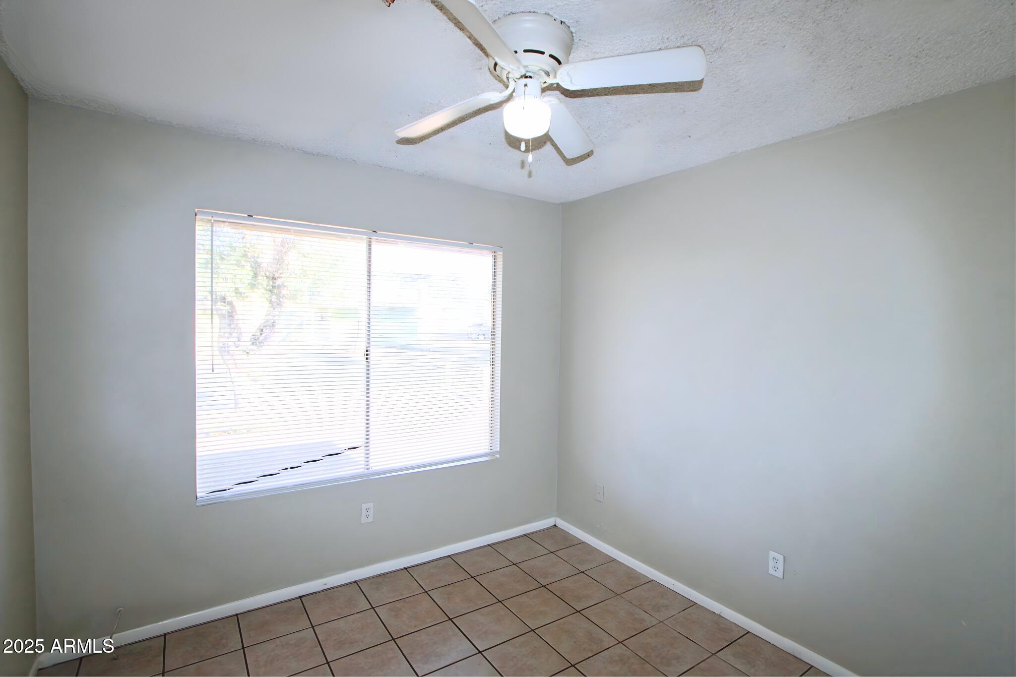 3313 West Harmont Drive, Unit 1 Phoenix, AZ 85051 - Photo 15 of 16 an empty room with windows and fan