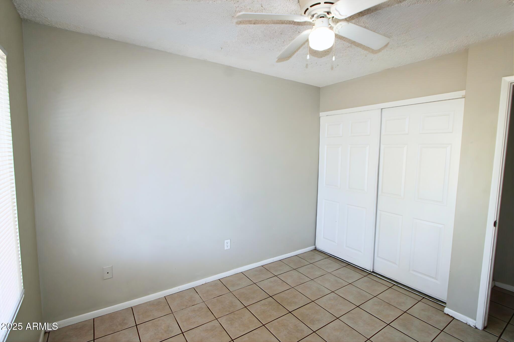 3313 West Harmont Drive, Unit 1 Phoenix, AZ 85051 - Photo 16 of 16 an empty room with fan and fan