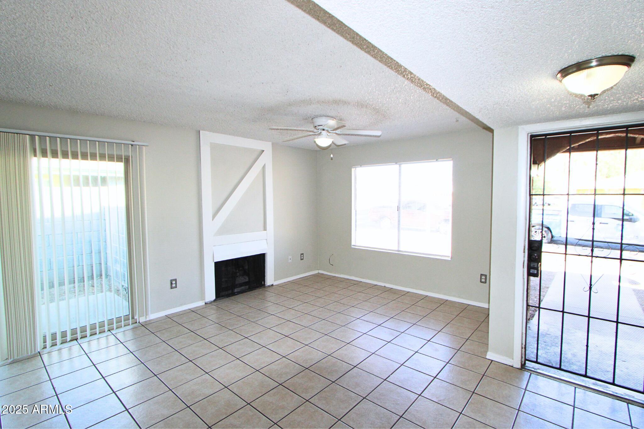 3313 West Harmont Drive, Unit 1 Phoenix, AZ 85051 - Photo 2 of 16 a view of an empty room with window and chandelier fan