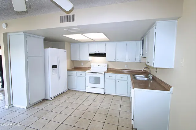a kitchen with a sink cabinets and refrigerator