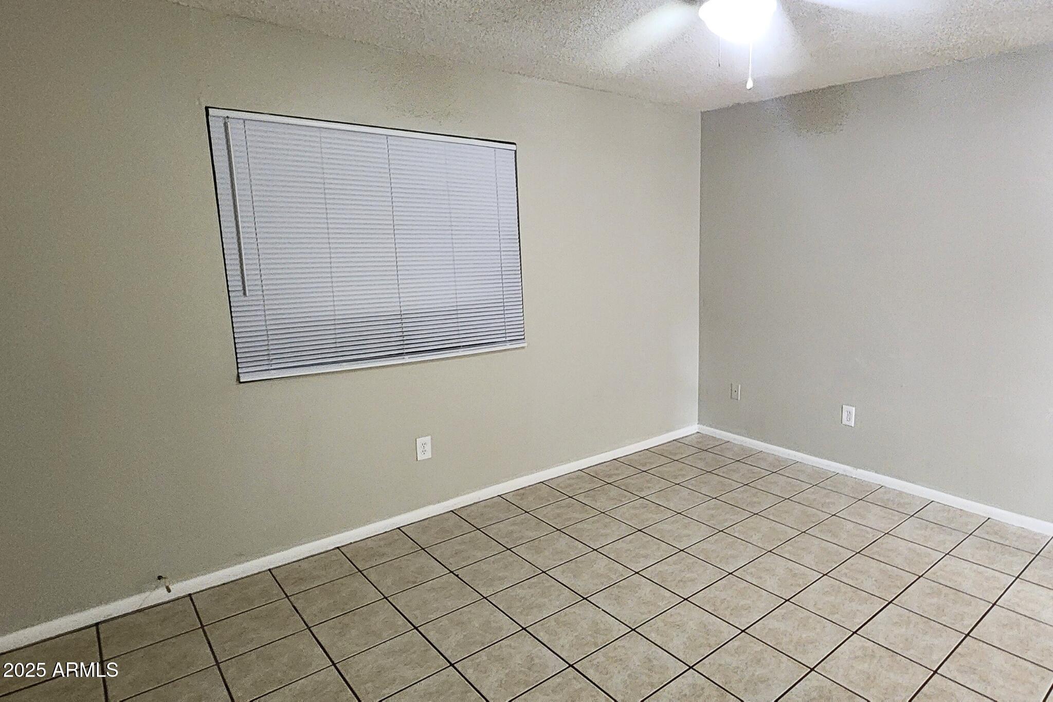 3313 West Harmont Drive, Unit 1 Phoenix, AZ 85051 - Photo 8 of 16 an empty room with windows
