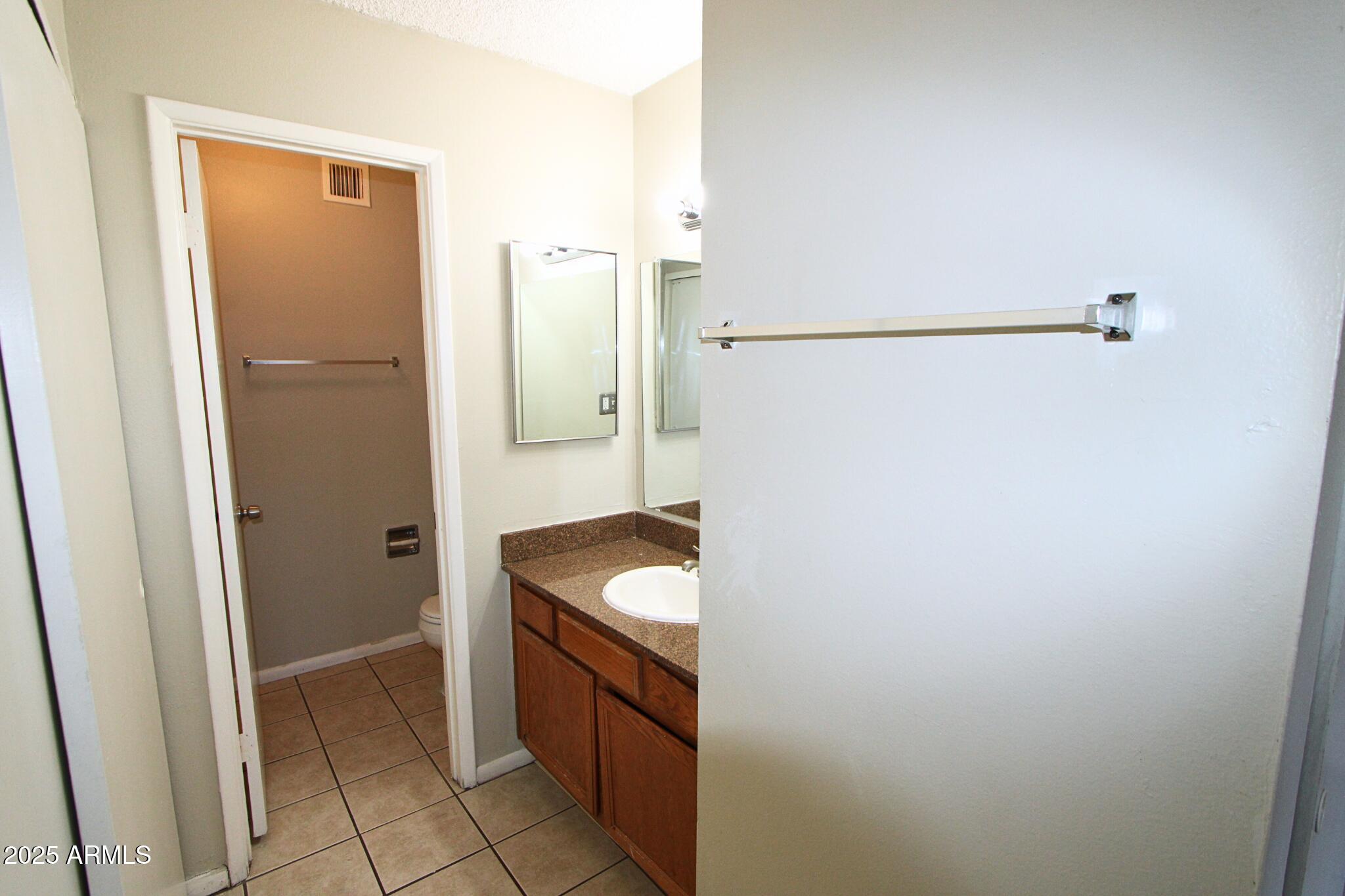 3313 West Harmont Drive, Unit 1 Phoenix, AZ 85051 - Photo 10 of 16 a bathroom with a granite countertop shower and a sink