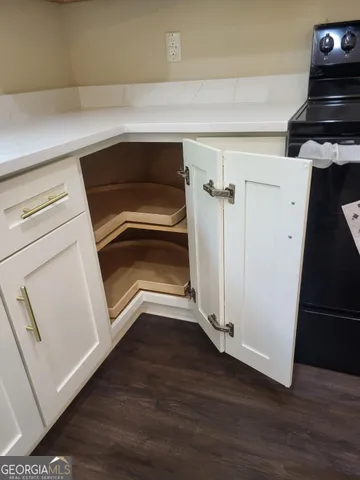 a view of a utility room with wooden floor and cabinets