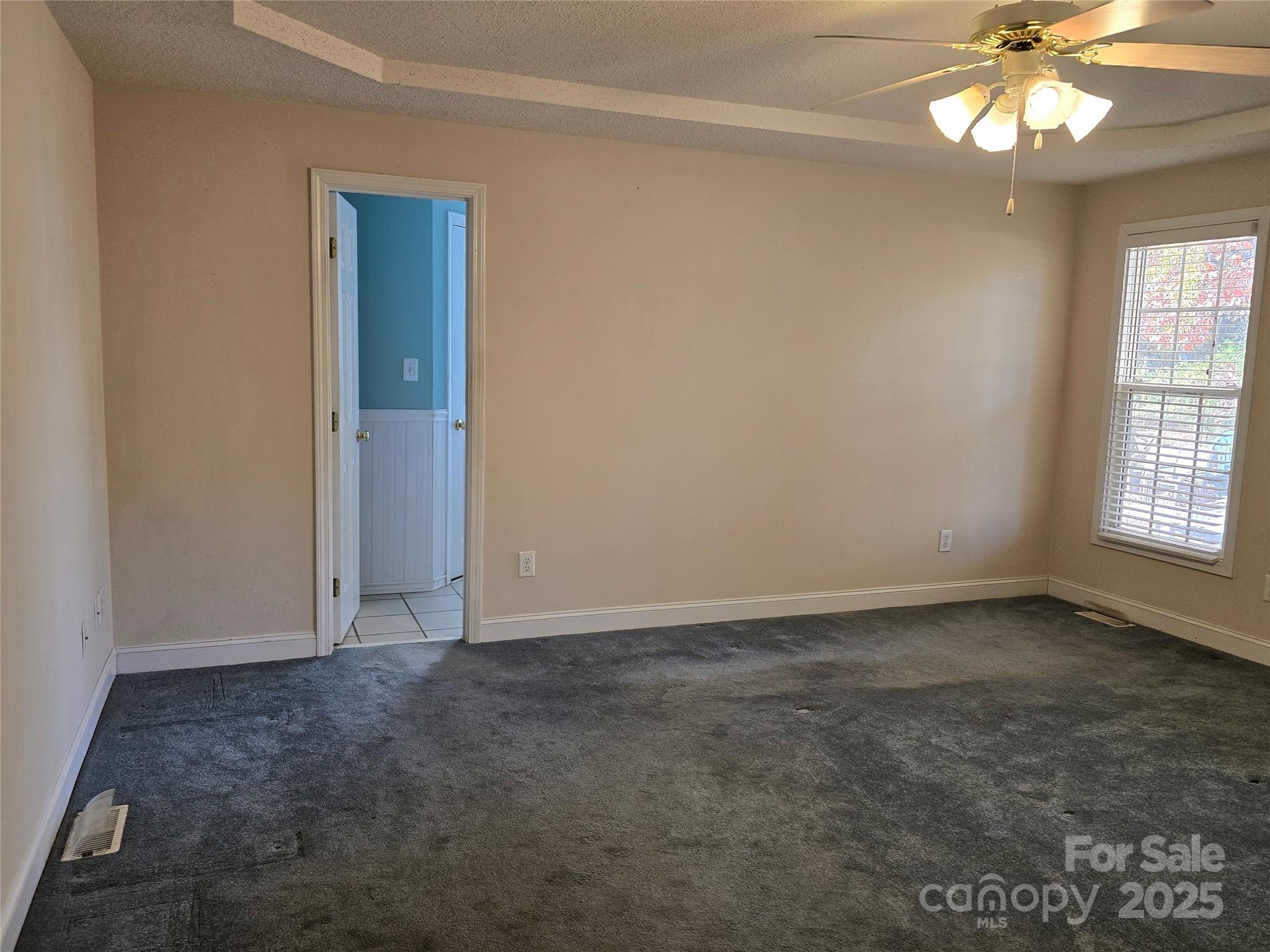 462 Cress Loop Road Salisbury, NC 28147 - Photo 19 of 48 an empty room with a chandelier fan and windows
