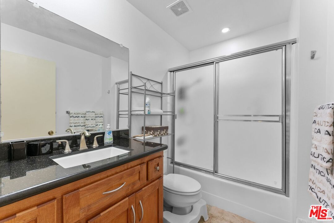 612 South Barrington Avenue, Unit 317 Los Angeles, CA 90049 - Photo 12 of 17 a bathroom with a granite countertop sink toilet and shower