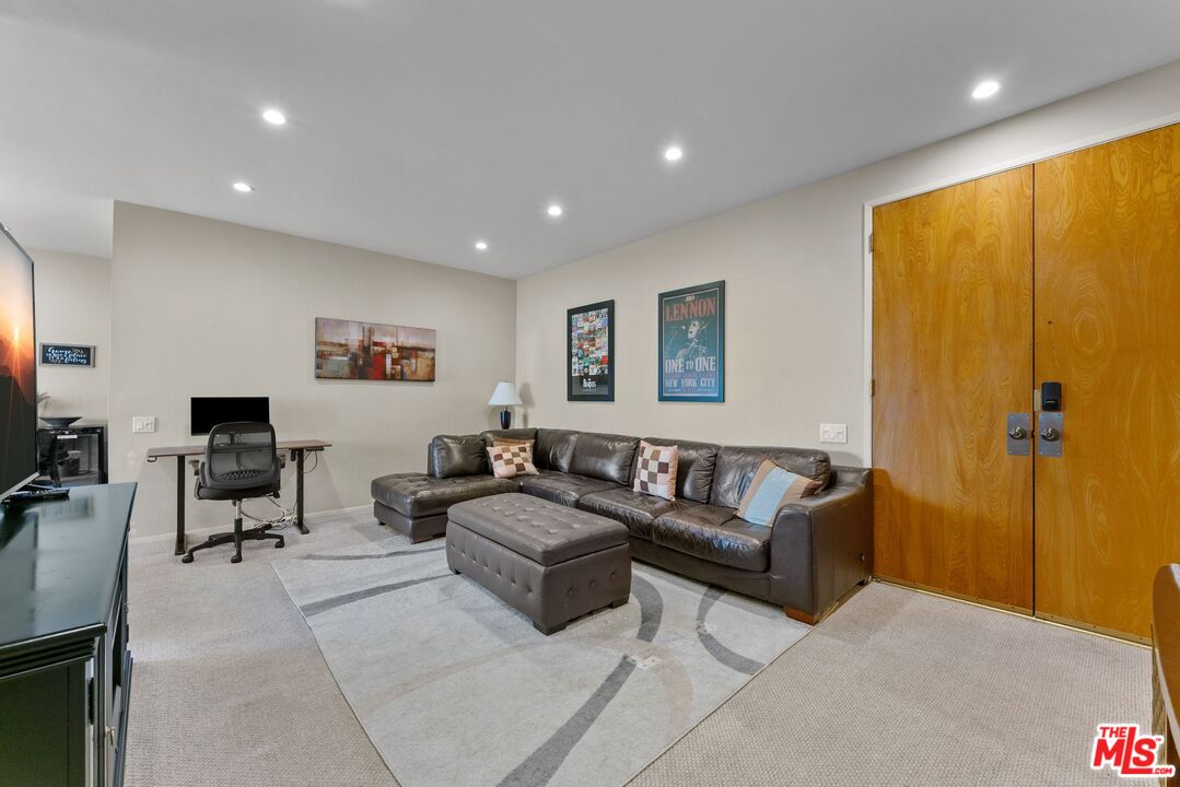 612 South Barrington Avenue, Unit 317 Los Angeles, CA 90049 - Photo 4 of 17 a living room with furniture and a flat screen tv