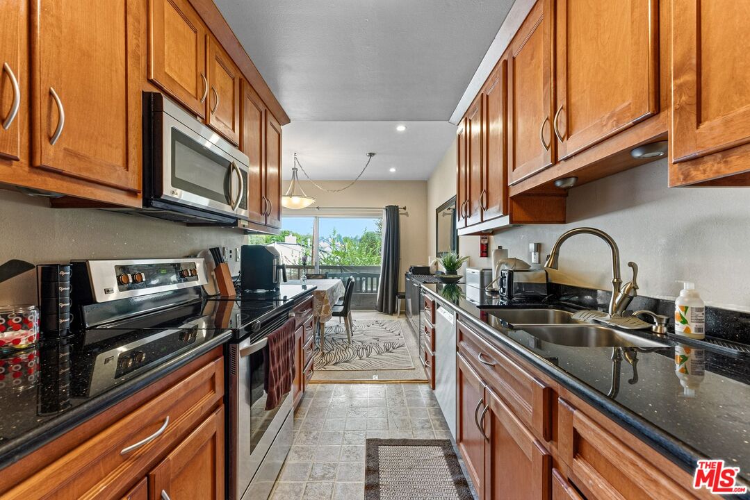 612 South Barrington Avenue, Unit 317 Los Angeles, CA 90049 - Photo 8 of 17 a kitchen with stainless steel appliances a sink a stove and cabinets